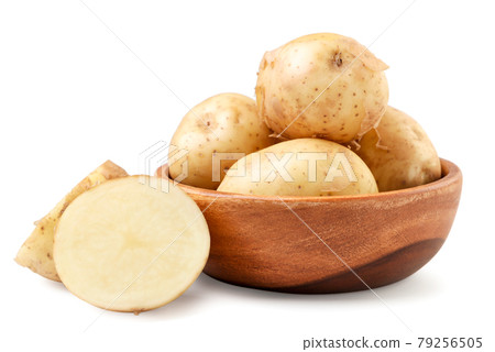 Young unpeeled potatoes whole and half in a wooden plate on a white background. Isolated 79256505
