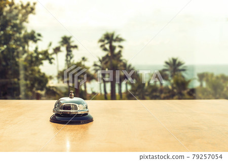 .The desk cafe, restaurant with a service bell for warn that the dish is ready. Roof of beach cafe with sea and palm tree view .The desk cafe, restaurant with a service bell for warn that the dish is ready. Roof of beach cafe with sea and palm tree view 79257054