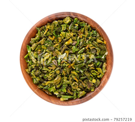 Dried green paprika flakes with seeds in wooden bowl, isolated on white background. Chopped jalapeno, habanero or chilli pepper. Spices and herbs. Top view. Dried green paprika flakes with seeds in wooden bowl, isolated on white background. Chopped jalapeno, habanero or chilli pepper. Spices and herbs. Top view. 79257219