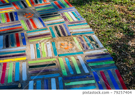 Top view on pieces of multicolored ceramic tiles decorated in garden. Old pavement of tiles textured. Street mosaic cobblestone sidewalk. Abstract,background and pattern of ceramic tile on the floor. 79257404