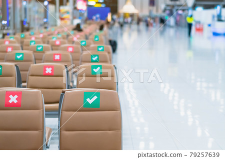 Rows empty brown chairs with the sticker sign sitting position for social distancing in waiting terminal of the airport to prevent of Corona virus (Covid-19). Safe travel new normal social distancing. Rows empty brown chairs with the sticker sign sitting position for social distancing in waiting terminal of the airport to prevent of Corona virus (Covid-19). Safe travel new normal social distancing. 79257639
