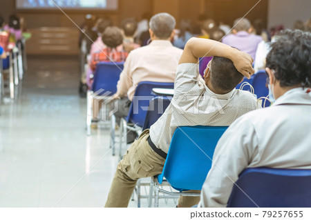 Back view of Asian man wear protective face mask to prevent Coronavirus(COVID-19) sitting on a chair for social distancing in auditorium. Conference concept in coronavirus pandemic.Selective focus. Back view of Asian man wear protective face mask to prevent Coronavirus(COVID-19) sitting on a chair for social distancing in auditorium. Conference concept in coronavirus pandemic.Selective focus. 79257655