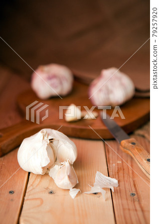 Garlic cloves and garlic bulb on a white wooden table Garlic cloves and garlic bulb on a white wooden table 79257920