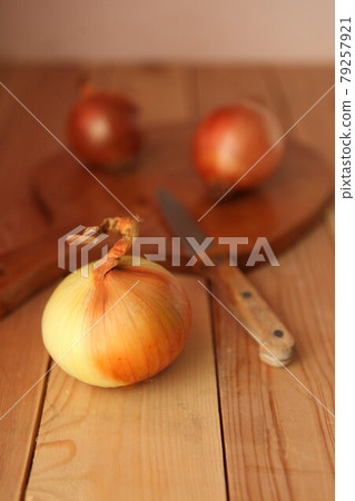 Onion and slices on wooden cutting board. onions at the wooden table Onion and slices on wooden cutting board. onions at the wooden table 79257921