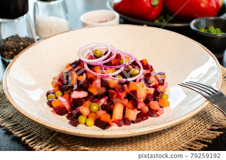 Vinaigrette. Traditional russian beetroot salad with boiled vegetables, pickled cucumbers, sour cabbage, olive oil and green canned peas. Vegetarian healthy dinner. Served in restaraunt. 79259192