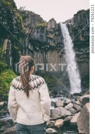 Iceland. Woman enjoying majestic Svartifoss waterfall. Female is visiting famous tourist attraction of Iceland. Spectacular natural landmark on vacation in Skaftafell. Icelandic nature landscape Iceland. Woman enjoying majestic Svartifoss waterfall. Female is visiting famous tourist attraction of Iceland. Spectacular natural landmark on vacation in Skaftafell. Icelandic nature landscape 79261221