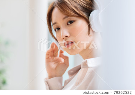 Young woman listening to music with headphones 79262522