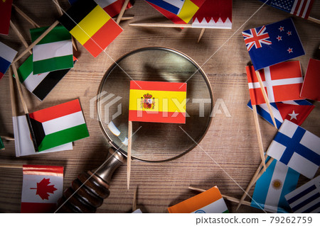Spanish Flag and magnifying glass. Flags of different countries on a wooden background Spanish Flag and magnifying glass. Flags of different countries on a wooden background 79262759