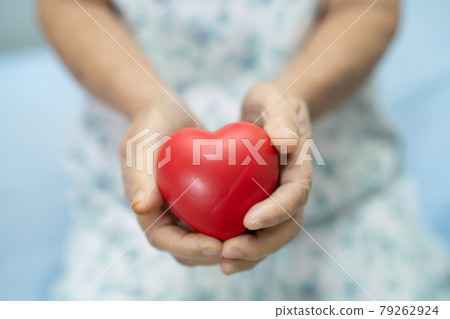 Asian senior or elderly old lady woman patient holding red heart in her hand on bed in nursing hospital ward, healthy strong medical concept Asian senior or elderly old lady woman patient holding red heart in her hand on bed in nursing hospital ward, healthy strong medical concept 79262924