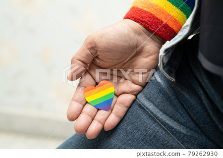 Asian lady wearing blue jean jacket or denim shirt and holding rainbow color flag heart, symbol of LGBT pride month celebrate annual in June social of gay, lesbian, bisexual, transgender, human 79262930