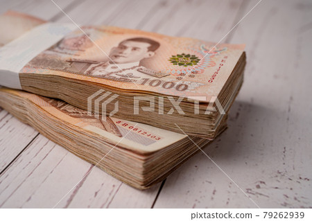 Stack of Thai baht banknotes on wooden background, business saving finance investment concept. Stack of Thai baht banknotes on wooden background, business saving finance investment concept. 79262939