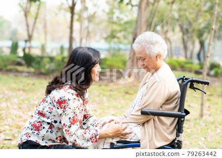 Asian senior or elderly old lady woman patient with care, help and support happy on wheelchair in park in holiday, healthy strong medical concept. Asian senior or elderly old lady woman patient with care, help and support happy on wheelchair in park in holiday, healthy strong medical concept. 79263442