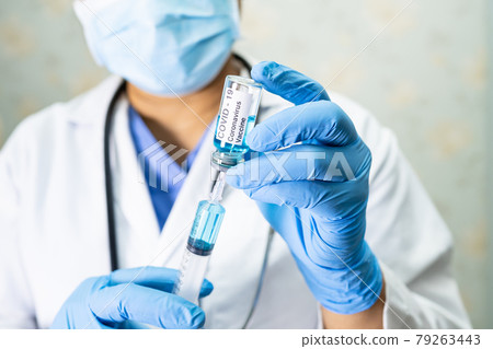 Doctor holding syringe with vaccine development medical for doctor use to treat illness patients Covid-19 coronavirus vaccine at hospital. 79263443
