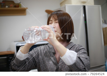 A woman drinking water A woman drinking water 79264524