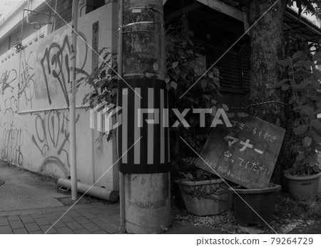 A black-and-white version of a sign that pays attention to graffiti in a corner of the shopping district 79264729