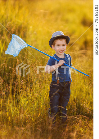 portrait of little happy boy in hat with butterfly net 79265183