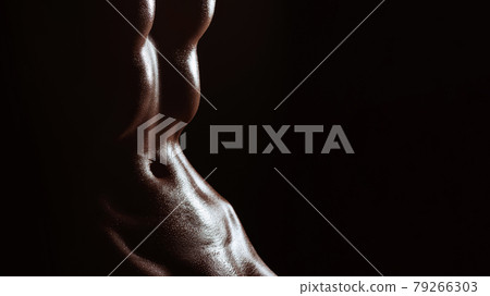 Sexy naked body of a girl in wet drops. Fitness slim figure of a woman 79266303