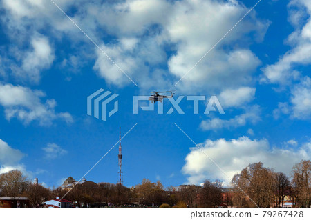 The helicopter takes off against the background of clouds and blue sky The helicopter takes off against the background of clouds and blue sky 79267428