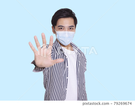 young man wears medical mask COVID-19 showing stop 79269674