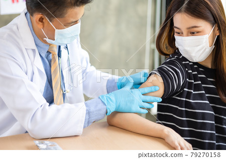 Senior doctor syringe injection to the young patient put on a mask in the hospital.Medical healthcare concept. Senior doctor syringe injection to the young patient put on a mask in the hospital.Medical healthcare concept. 79270158
