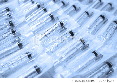 Medical syringes in a package. A bunch of unused, packaged syringes.Many new syringes lie strewn on a flat surface. Medical syringes in a package. A bunch of unused, packaged syringes.Many new syringes lie strewn on a flat surface. 79271028
