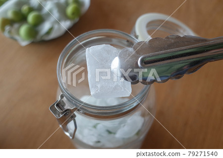 用冰糖和蛋捲裝滿消毒過的罐子 用冰糖和蛋捲裝滿消毒過的罐子 79271540