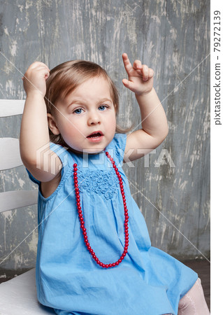 little girl sitting on chair is pointing little girl sitting on chair is pointing 79272139