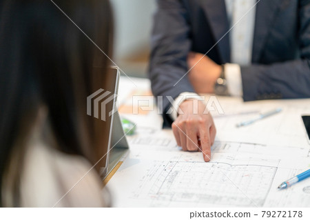 A male first-class architect who carefully explains drawings to customers without a face 79272178