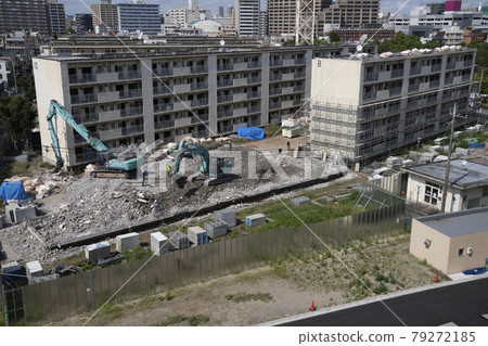 Old apartment building under demolition, shovel car 79272185