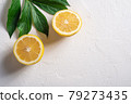 Two lemon slices, tropical citrus fruits with green leaves on white concrete background, top view copy space 79273435