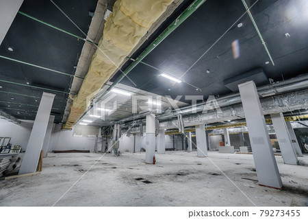Construction of spacious well-lit underground car park with parking spaces. Empty parking garage underground, industrial interior Construction of spacious well-lit underground car park with parking spaces. Empty parking garage underground, industrial interior 79273455