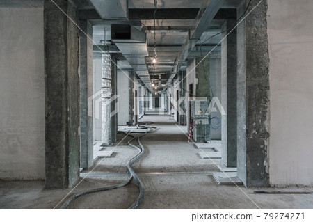 Interior construction site. Finishing works in hall of commercial building. Building is ready for decoration. Preparation for communications. Engineering communications in building under construction Interior construction site. Finishing works in hall of commercial building. Building is ready for decoration. Preparation for communications. Engineering communications in building under construction 79274271