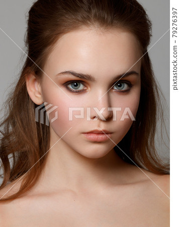 Gorgeous Young Brunette Woman face portrait. Beauty Model Girl with perfect eyebrows , clean make-up . Sexy lady makeup for party. Isolated on gray background Gorgeous Young Brunette Woman face portrait. Beauty Model Girl with perfect eyebrows , clean make-up . Sexy lady makeup for party. Isolated on gray background 79276397