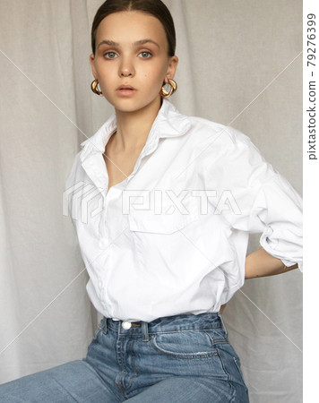 Beautiful female model . Beauty woman . Model test portrait with fashion girl in shirt and jeans on a textile background. Natural makeup and wavy hairstyle Beautiful female model . Beauty woman . Model test portrait with fashion girl in shirt and jeans on a textile background. Natural makeup and wavy hairstyle 79276399