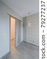Sliding door in finishing apartment interior. Empty room in new building with repair, walls with wallpapers. Repair works on construction site of residential apartment. 79277237