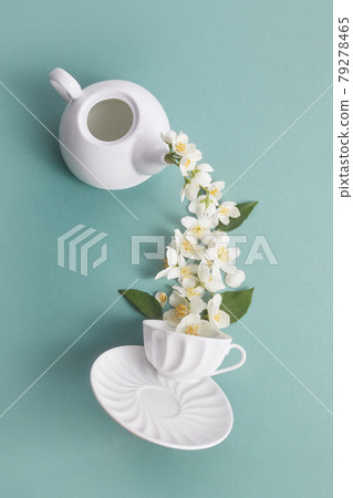 Layout of teapot and tea Cup with Jasmine flowers on a green background. Jasmine tea. Layout of teapot and tea Cup with Jasmine flowers on a green background. Jasmine tea. 79278465