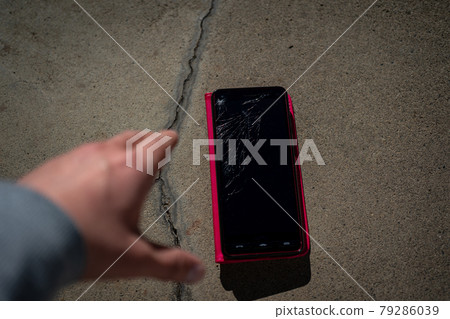 A man who dropped his smartphone on concrete and the screen cracked 79286039