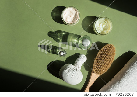 Body treatment and spa concept. Scrub, mask, cream and natural oil cosmetics on green background. Cellulite treatment, dry brushing. Womans cosmetic procedures 79286208