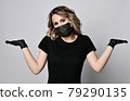 Blonde curly woman in black t-shirt, protective 79290135