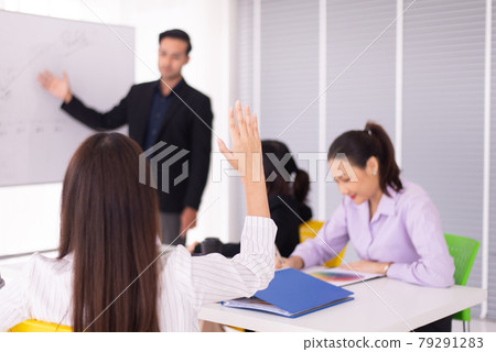 Audience woman raised hand and arm during meeting seminar,People sharing ideas and brainstorm,Asking and answer concept Audience woman raised hand and arm during meeting seminar,People sharing ideas and brainstorm,Asking and answer concept 79291283