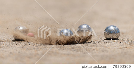 Petanque ball boules bowls on a dust floor, photo in impact. Balls and a small wood jack 79293509