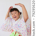 A child in a yukata dancing a Bon festival dance 79295620
