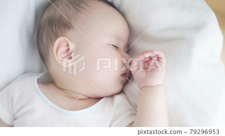 Baby sleeping in a cot 79296953