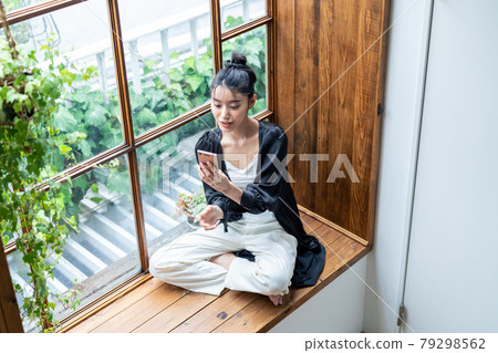 A young woman looking at a smartphone at home 79298562