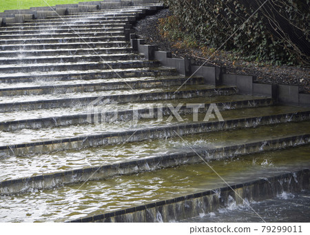 Water flows down the stone steps of the stairs. 79299011