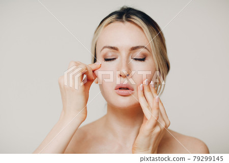 Woman doing facial gymnastics self yoga massage and exercises for face skin. 79299145
