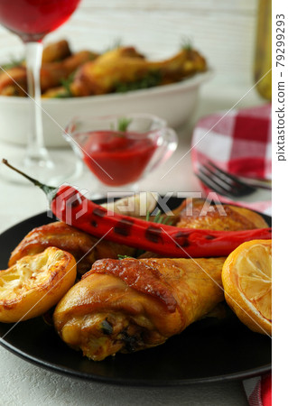 Concept of delicious eating with roast chicken drumsticks on white textured table 79299293