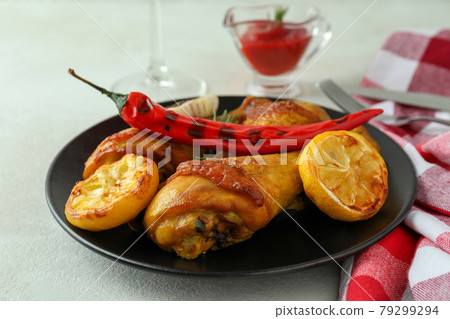 Concept of delicious eating with roast chicken drumsticks on white textured table Concept of delicious eating with roast chicken drumsticks on white textured table 79299294