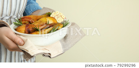 Woman hold baking tray with roast chicken drumsticks Woman hold baking tray with roast chicken drumsticks 79299296