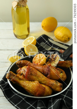 Concept of delicious eating with pan of roast chicken drumsticks on white wooden table Concept of delicious eating with pan of roast chicken drumsticks on white wooden table 79299303